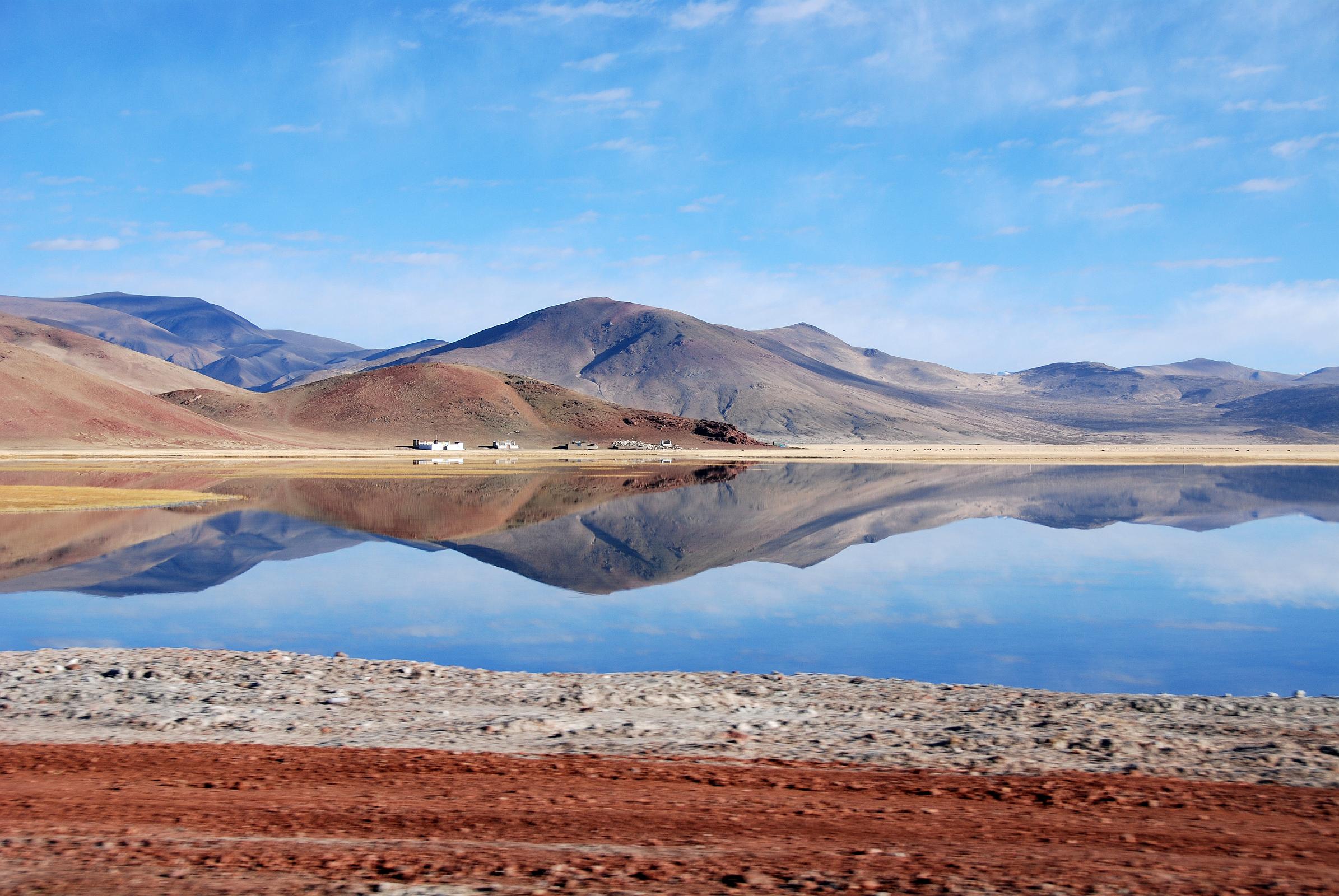 39 Hills Reflect Perfectly In The Water Just After Leaving Paryang Tibet For Mount Kailash The colourful hills of Tibet reflect perfectly in the water after leaving Paryang Tibet for Mount Kailash.
